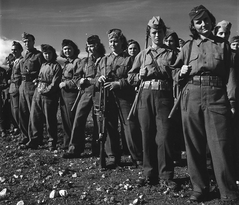 Греческие партизаны в строю. Девушки вооружены трофейными итальянскими винтовками, третья девушка справа — 6,5-мм итальянским пулеметом Breda modello 30
