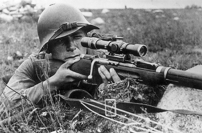 Советский снайпер ведет огонь из винтовки Мосина с прицелом ПЕ. Август 1941 года.