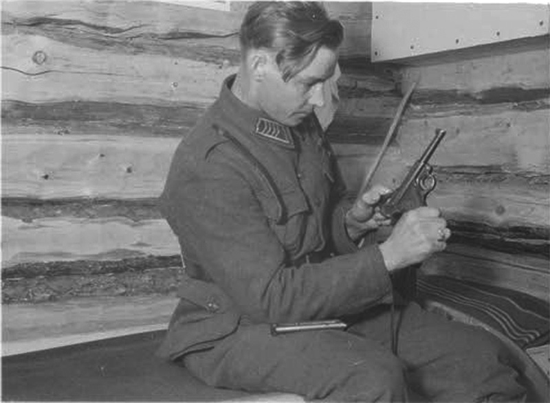 Финский солдат осматривает пистолет Р.08