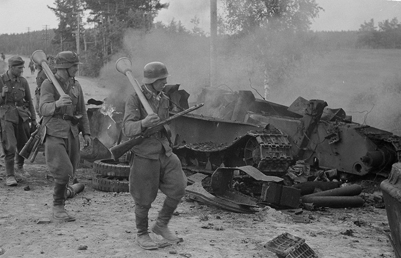 Финские солдаты  проходят мимо разрушенного взрывом советского танка Т-34, июнь-июль 1944 года