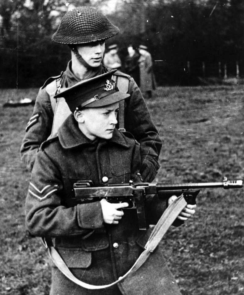 Обучение учащихся одной из английских школ владению стрелковым оружием, у мальчика в руках Thompson M1921A